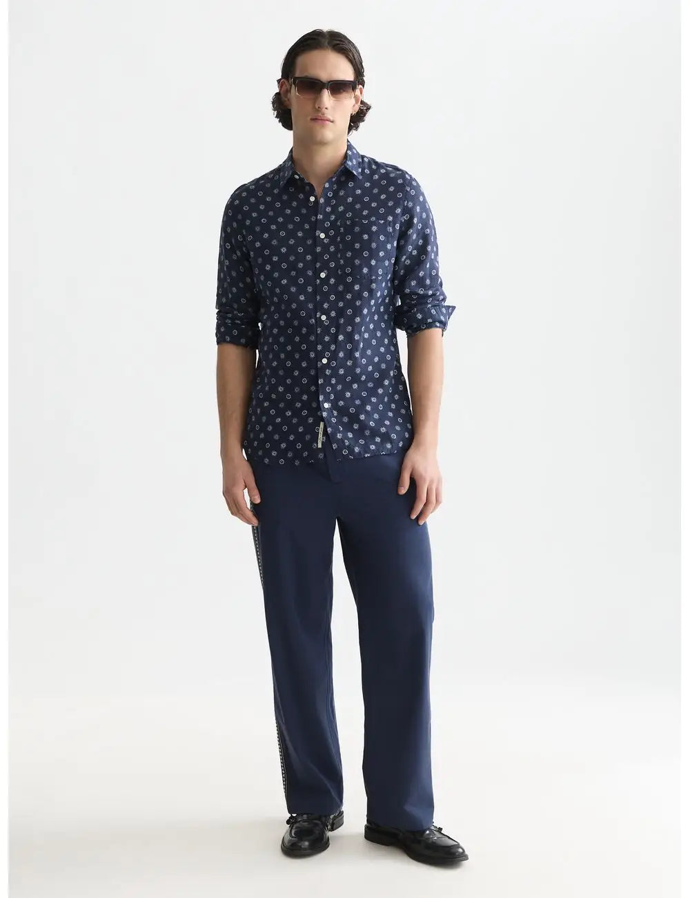 Man wearing a navy patterned shirt and pants on a white background by Scotch & Soda