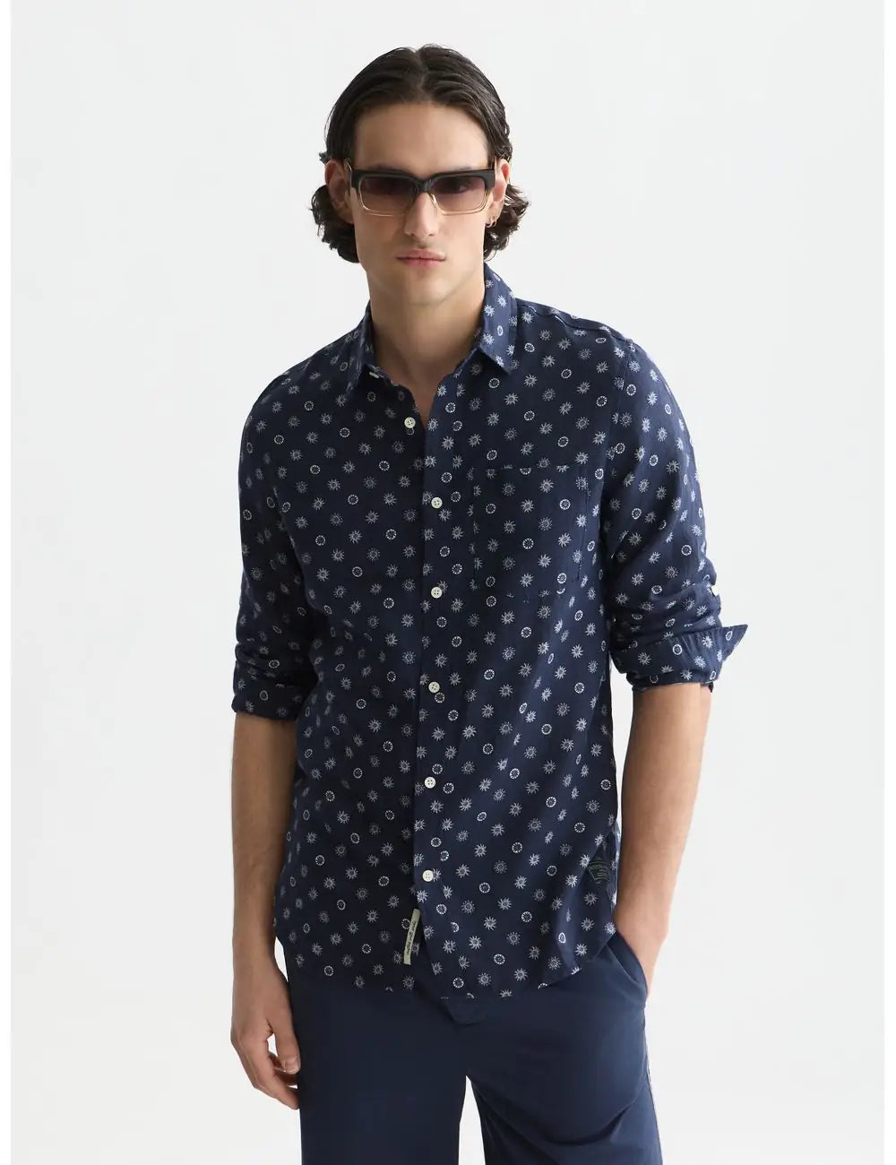Man wearing a navy patterned shirt and sunglasses on a white background by Scotch & Soda
