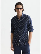 Man wearing a navy patterned shirt and sunglasses on a white background by Scotch & Soda